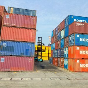a forklift is moving a large stack of shipping containers